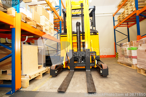 Image of Forklift, shelves and racks with pallets in distribution warehou