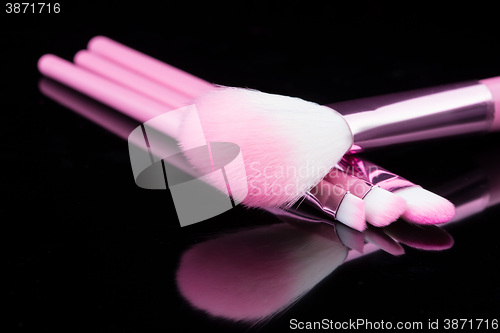 Image of lipstick with a brush make-up on black 