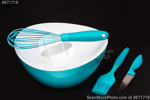 Image of Green silicone pastry brush and soup plate isolated on black