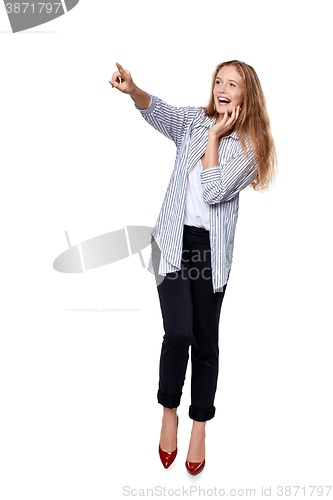 Image of Happy excited woman in full length pointing to the side