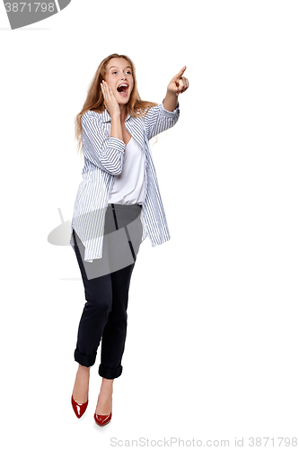 Image of Happy excited woman in full length pointing to the side