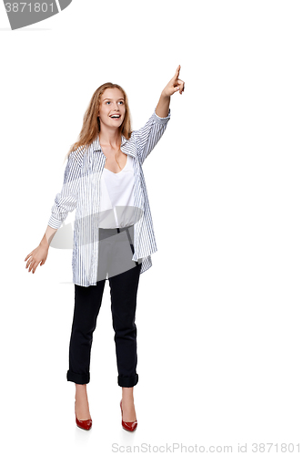 Image of Happy excited woman in full length pointing to the side