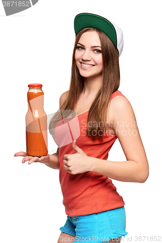 Image of Happy teen girl holding a bottle of carrot juice