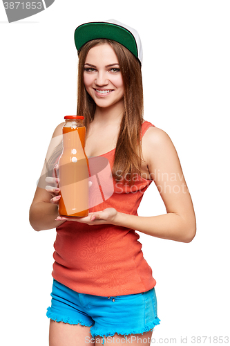 Image of Happy teen girl holding a bottle of carrot juice