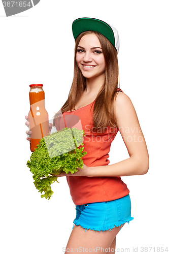 Image of Happy teen girl holding a bottle of carrot juice