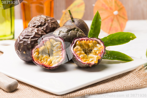 Image of Passion fruits on white ceramic tray on wooden table background.