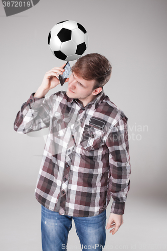 Image of Portrait  of young man with smart phone and football ball