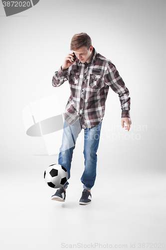 Image of Portrait  of young man with smart phone and football ball