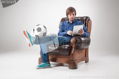 Image of Portrait of young man with laptop and football ball