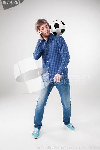 Image of The portrait of fan with ball, holding phone on white background