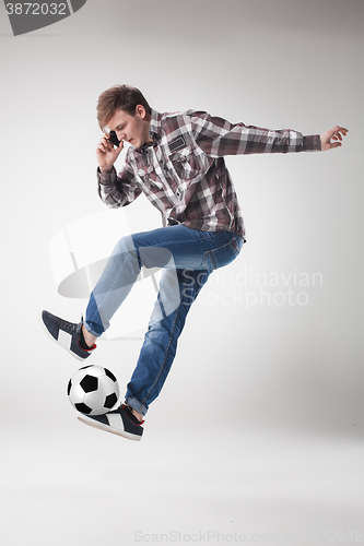 Image of Portrait  of young man with smart phone and football ball