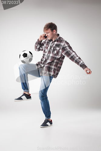 Image of Portrait  of young man with smart phone and football ball