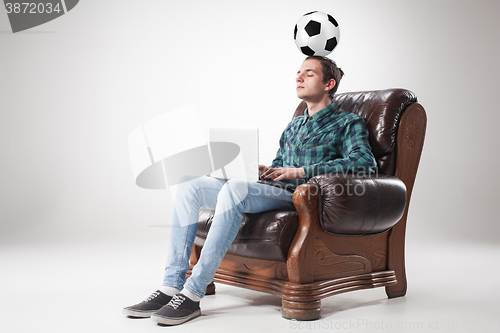 Image of Portrait of young man with laptop and football ball