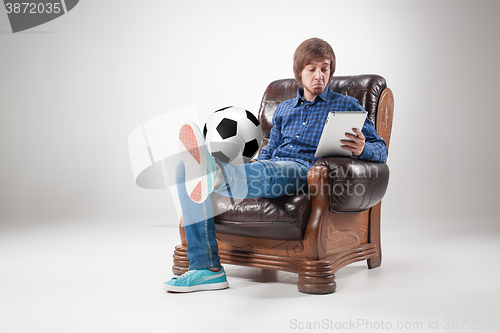 Image of Portrait of young man with laptop and football ball