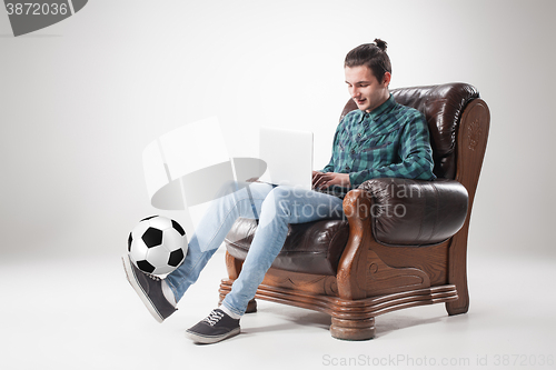 Image of Portrait of young man with laptop and football ball