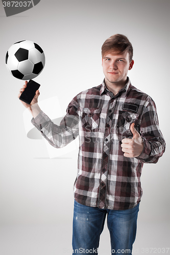 Image of Portrait  of young man with smart phone and football ball