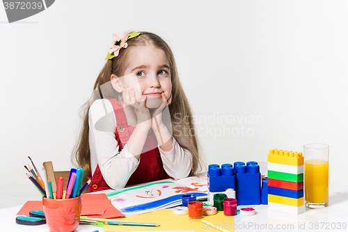 Image of Cute little girl drawing with paint and paintbrush at home