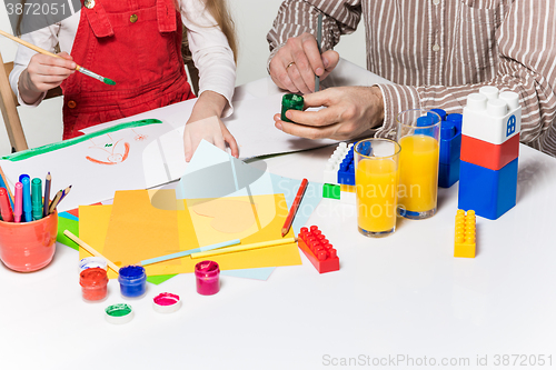 Image of The daughter and father carving out paper applications 