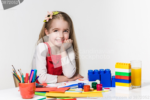 Image of Cute little girl drawing with paint and paintbrush at home