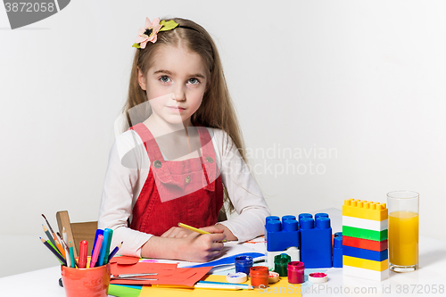 Image of Cute little girl drawing with paint and paintbrush at home