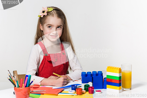 Image of Cute little girl drawing with paint and paintbrush at home
