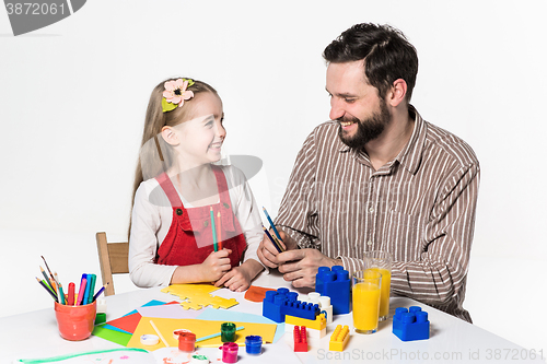 Image of The daughter and father carving out paper applications 