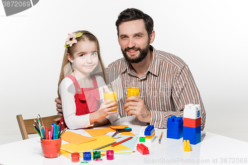 Image of Father and daughter drinking juice