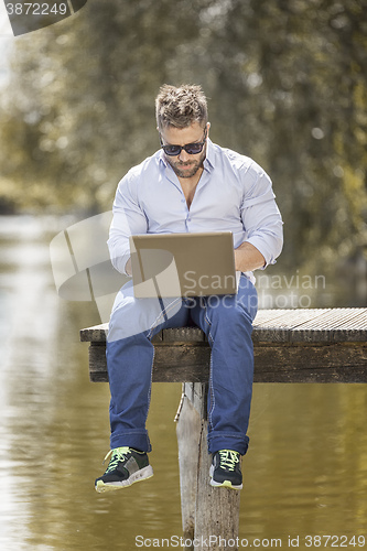 Image of man at the lake with notebook