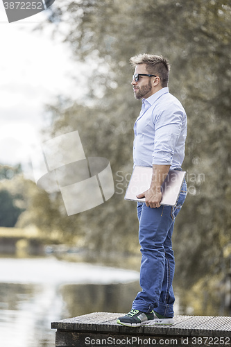 Image of man at the lake with notebook