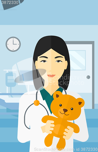 Image of Pediatrician holding teddy bear.