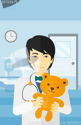 Image of Pediatrician holding teddy bear.