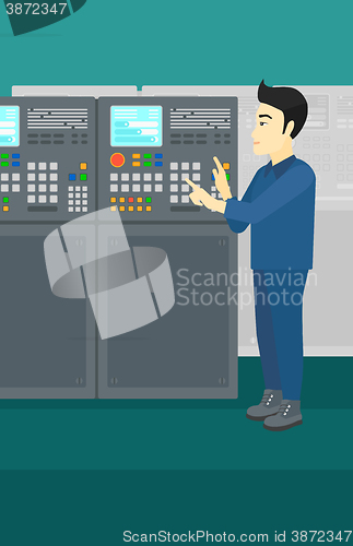 Image of Engineer standing near control panel.