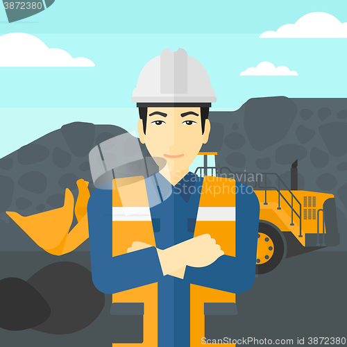 Image of Miner with mining equipment on background.