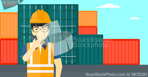 Image of Stevedore standing on cargo containers background.