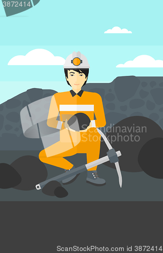 Image of Miner holding coal in hands.