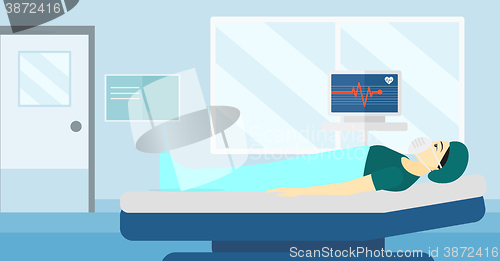 Image of Patient lying in hospital bed with heart monitor.