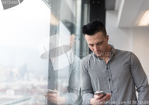 Image of young business man using smart phone at office