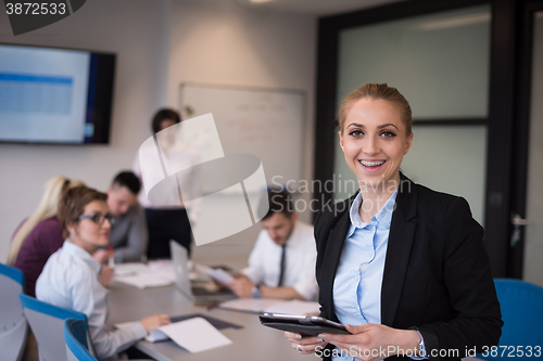 Image of business woman working on tablet at meeting room