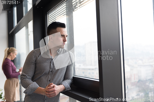 Image of business man at office looking through window