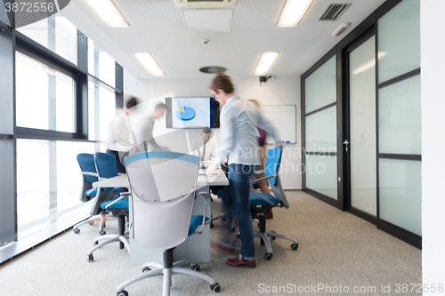 Image of business people group entering meeting room, motion blur