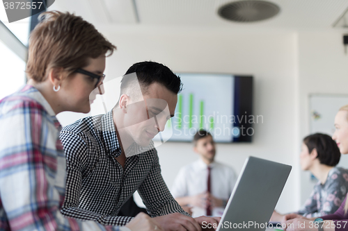 Image of young business couple working on laptop, businesspeople group on