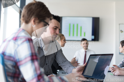 Image of young business couple working on laptop, businesspeople group on