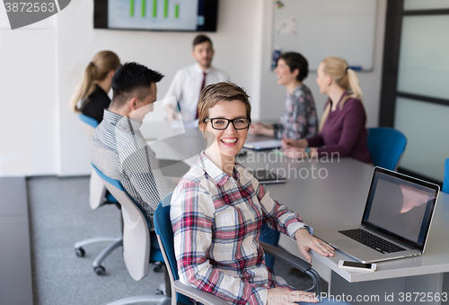 Image of young business woman at office working on laptop with team on me