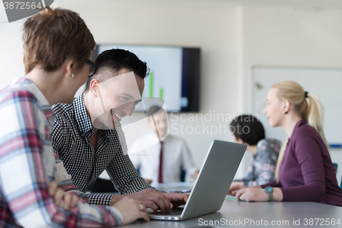 Image of young business couple working on laptop, businesspeople group on