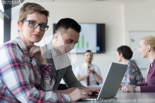Image of young business couple working on laptop, businesspeople group on