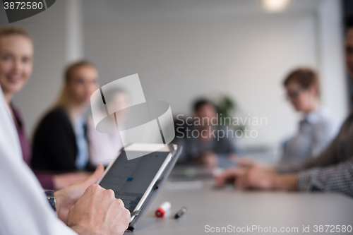 Image of close up of  businessman hands  using tablet on meeting