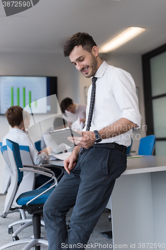 Image of young business man with tablet at office meeting room