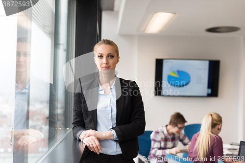 Image of portrait of young business woman at office with team on meeting 
