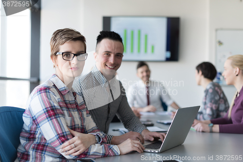 Image of young business couple working on laptop, businesspeople group on