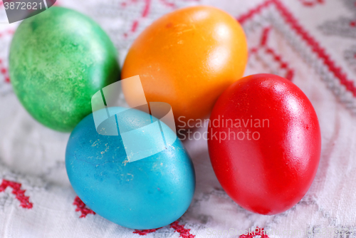 Image of Four colorful easter eggs on linen tablecloth